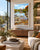 A framed landscape art print depicting a scenic river Dee with rocks, autumn foliage, and a church steeple, displayed on a wall in a modern, sunlit living room with a sofa, coffee table, and plants.